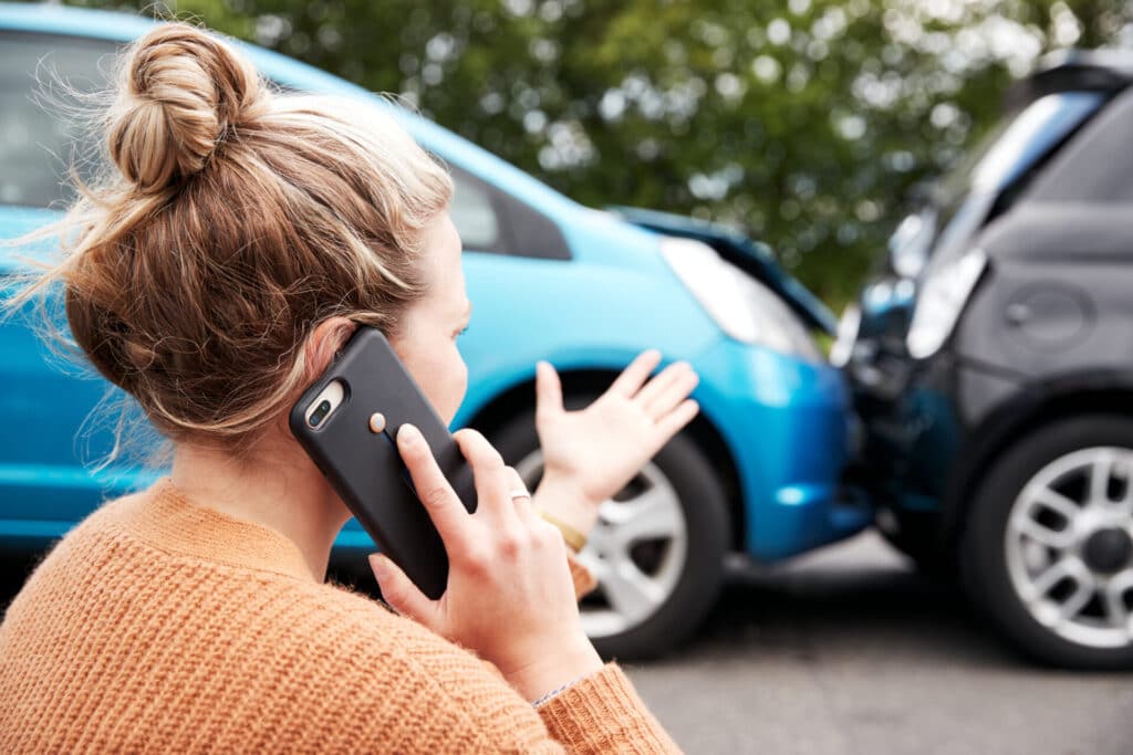 Woman calling in a car crash - auto insurance
